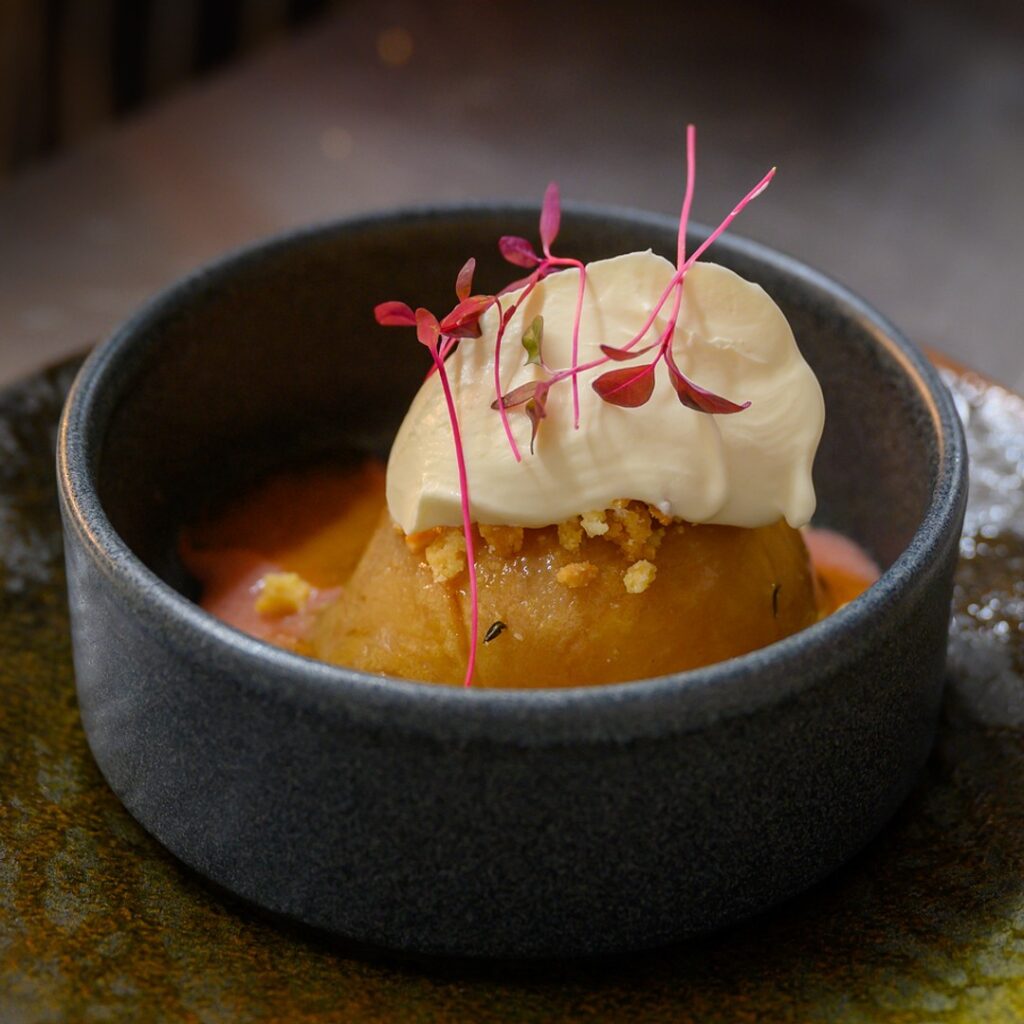 Poached pear pudding with clotted cream and micro herbs at The Fox at Walton, Wetherby