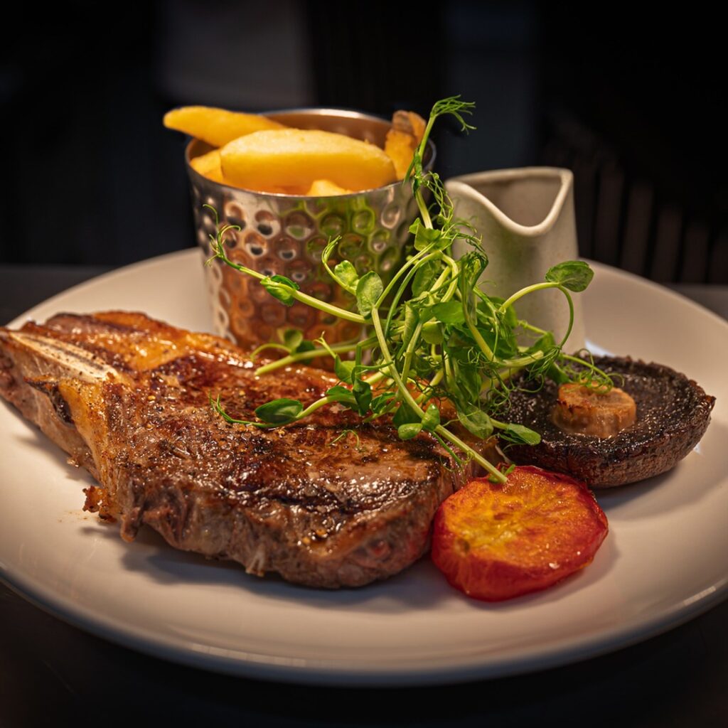 Grilled sirloin steak with chips, roasted tomato, mushroom and pea shoots at The Fox at Walton, Wetherby
